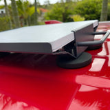 Close-up of Starlink Mini magnetic roof mount bracket and rubber magnets secured to a red vehicle roof