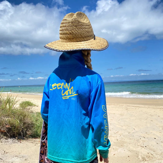 Child wearing a sun-safe kids fishing shirt at the beach during a caravanning and camping trip in Australia.