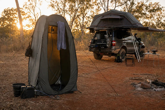 Pop-up shower tent set up at a remote Australian bush camp beside a 4WD with rooftop tent