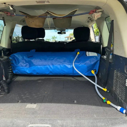 Blue Fleximake water bladder stored in the boot of a 4WD with hose attached