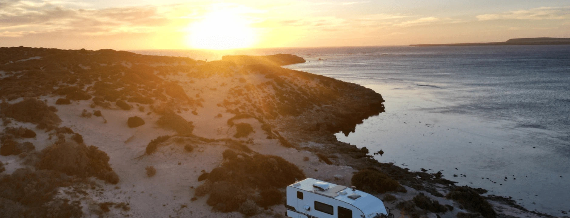 Campalot caravan overlooking a remote Australian coastline at sunset
